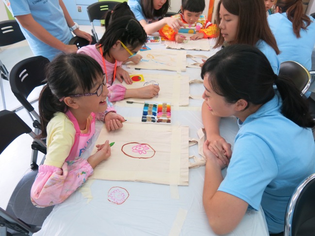 義工與兒童合力為環保袋添上色彩。 