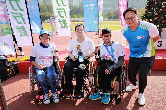 協會服務使用者莊桂南（左二）及Mohammad Sahad同學（右二）於「兩公里輪椅賽公開組」包攬冠軍及季軍。 