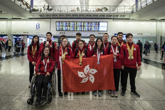 焦同學（前排左三）展示獎牌並手持香港區旗，與其他得獎者合照。 