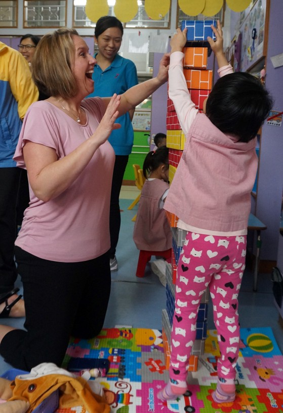嘉賓參與課堂活動，與幼兒合力把方塊積木砌高。 