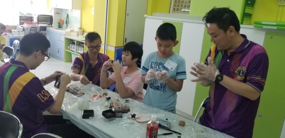  The volunteers guided and helped the children to make mooncakes patiently. 
