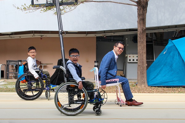 Mr. Suen Yau Man, Principal of the Jockey Club Elaine Field School, tried out ‘My Very Own Wheelchair’ with the students.