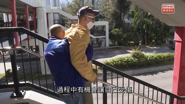 蔡爸爸長年累月幫助下肢癱瘓的兒子學行,最終導致自己頸部移位。(香港電台影片截圖) 蔡爸爸長年累月幫助下肢癱瘓的兒子學行,最終導致自己頸部移位。(香港電台影片截圖)