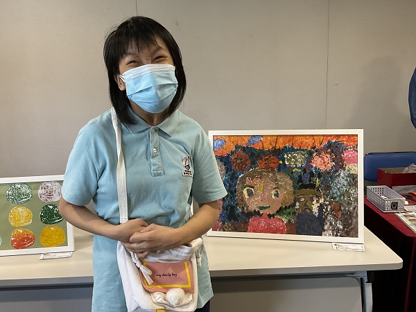 Student Li Ling Ling, from KFI, took a photo with her painting