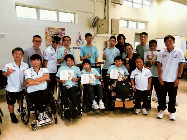 多位殘疾運動員大使（白衫者），還有殘奧金牌得主蘇樺偉先生（後排左四），與賽馬會田綺玲學校的同學和職員，還有孫友民校長（後排左一）合照。