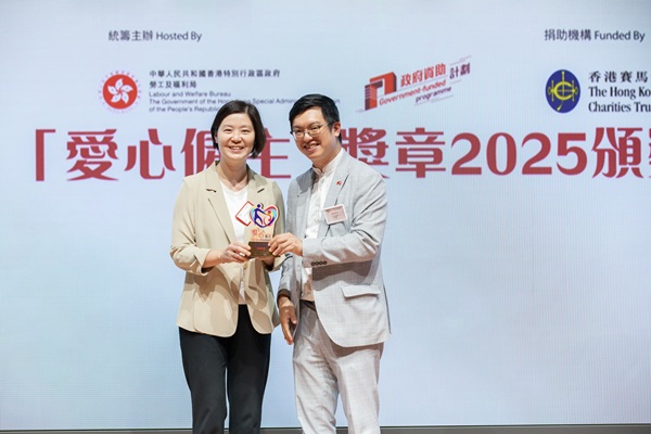 協會副行政總裁洪淑娟女士（左）從勞福局副局長何啟明先生, JP手上領取「愛心僱主」獎項。